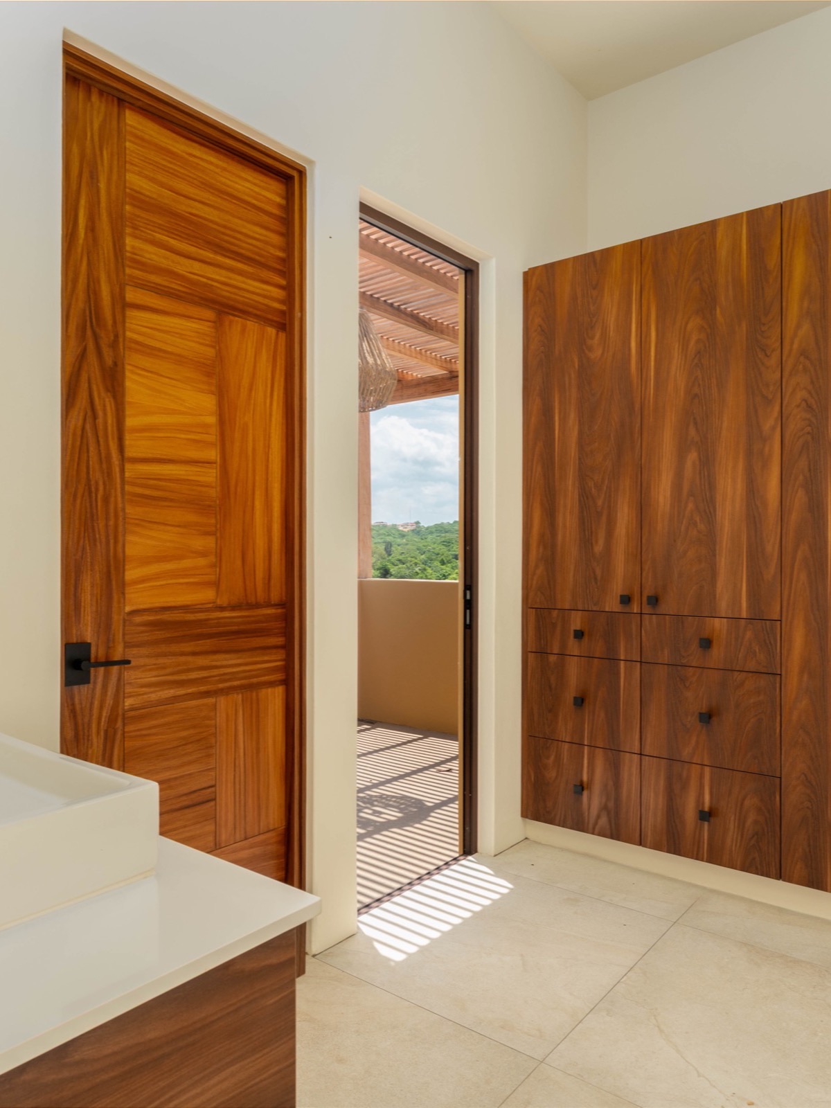 Carpintería en madera maciza: puerta y clóset de nogal en una residencia ROCA en Bahías de Huatulco