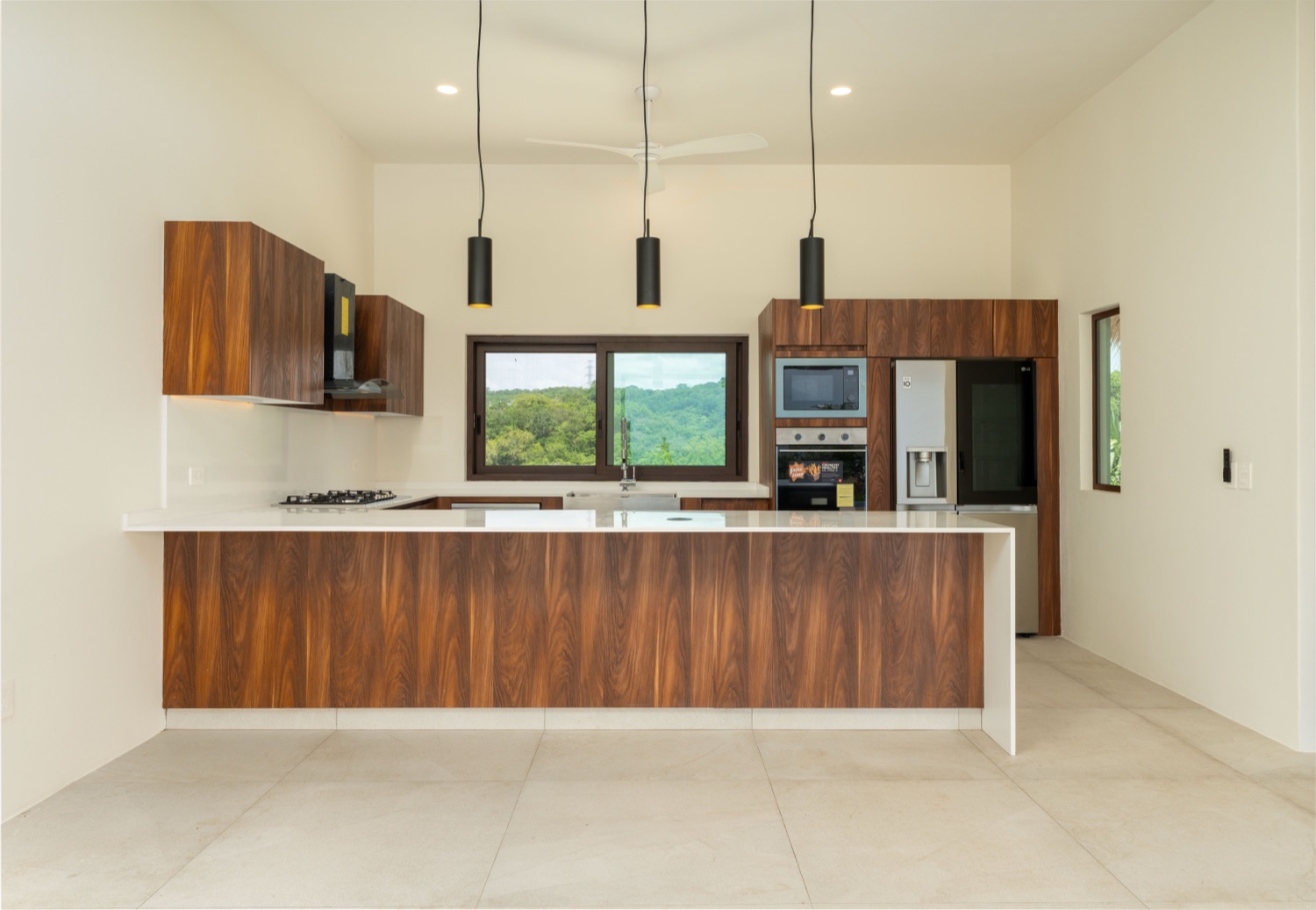 Cocina con carpintería de nogal, cubiertas de cuarzo y vista al jardín